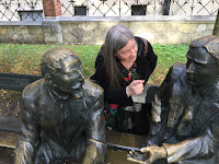 Sheila is Talking to 2 Seated Statues of Mathematicians in Krakow